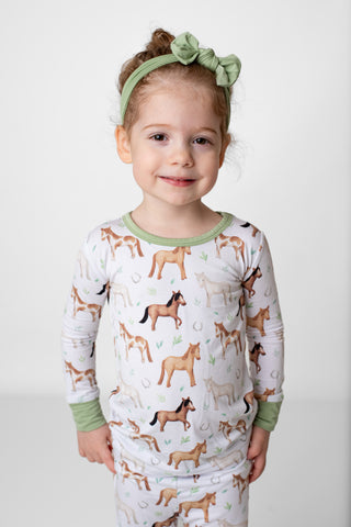 Girl wearing bamboo pajamas for toddlers and kids in Perfect Ponies print