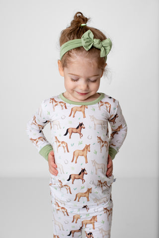 Girl wearing bamboo pajamas for toddlers and kids in Perfect Ponies print