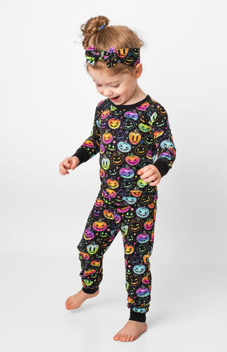 Girl wearing bamboo pajamas for toddlers and kids in Halloween Pumpkins print