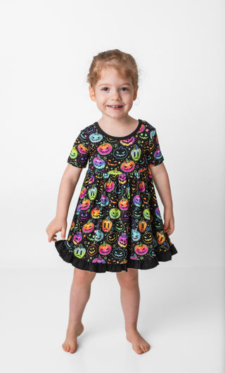 Girl wearing bamboo ruffle dress for toddlers and kids in Halloween Pumpkins print