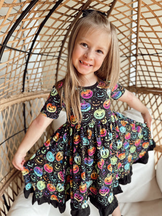 Girl wearing bamboo ruffle dress for toddlers and kids in Halloween Pumpkins print