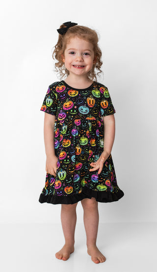 Girl wearing bamboo ruffle dress for toddlers and kids in Halloween Pumpkins print